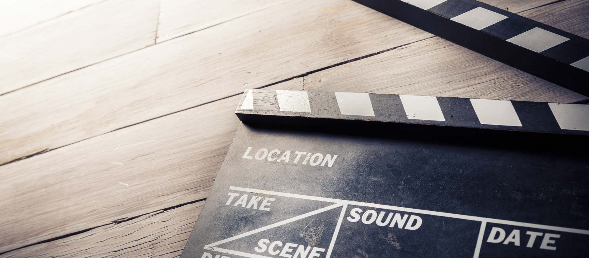 Eine Filmklappe liegt auf einem Parkettboden